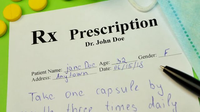 Prescription for tablet pills or drugs on green background with bottle and yellow tablets or pills and medical mask and black pen