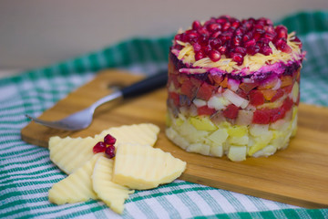 The dish is prepared in layers of salted herring, potatoes, beets, carrots, eggs and cheese on a green napkin.