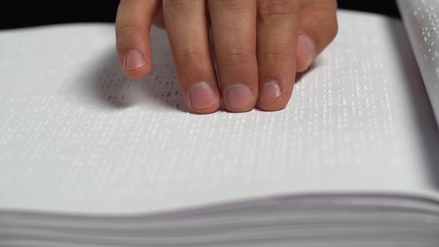 Male Hands Reading a Braille Book. Close up