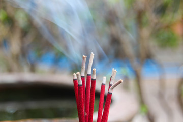 Red incense with white smoke.
