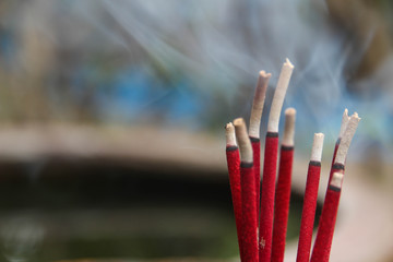 Red incense with white smoke.