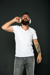 Mature hipster with beard. Confident and handsome Brutal man. Male barber care. Bearded man. Hair and beard care. happy bearded man hip ster listen music. audio book with headset. brutal tattoed male © be free