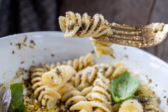 Fusilloni spiral pasta with pesto and parmesan in white bowl