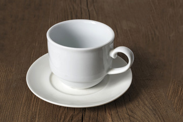 Empty white coffee cup on a wooden old table.