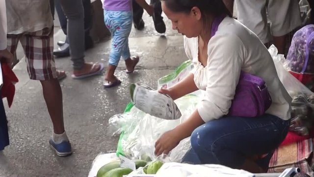 Street vendor unpacking vegetables in street flea market