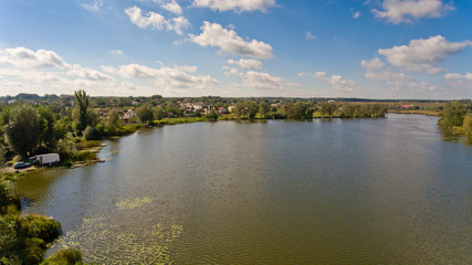 Fototapeta na wymiar Beautiful rural lake surrounded by green trees. Landscape of nature. Aerial view.