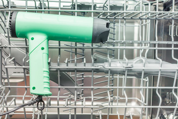 Green hairdryer is in the dishwasher