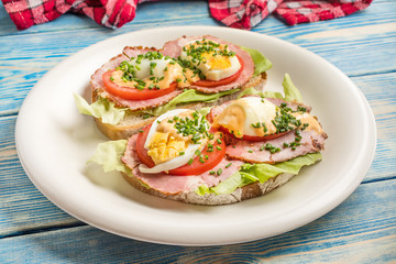 Fototapeta na wymiar Sandwich with tomatoes, eggs and lettuce.