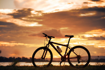 Fototapeta na wymiar Silhouette bicycle with sunset or sunrise background
