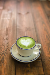 Green tea latte isolated on wooden table