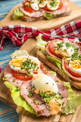 Sandwich with tomatoes, eggs and lettuce.