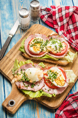 Sandwich with tomatoes, eggs and lettuce.