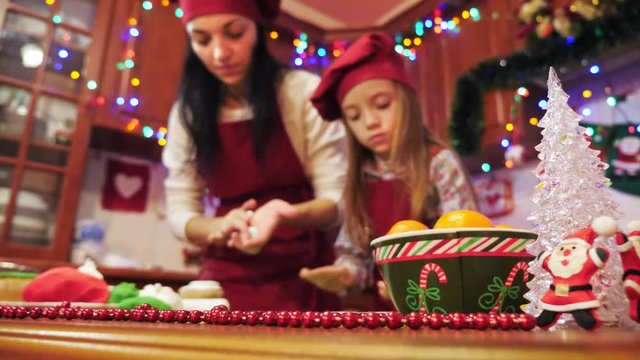 Mother and daughter are making decorations with sugar mastic for cupcake