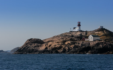 Navigation at sea. Lighthouse on a cliff. Norway