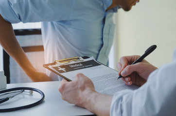 young business man suffering from backache meet doctor writing prescription on clipboard with...