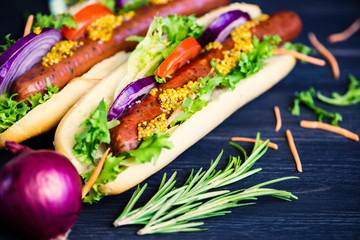 delicious hot dog with vegetables and sausage on a black background