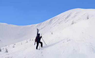Alpine touring skier hiking in winter mountains.