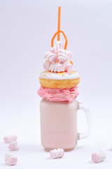 Pink strawberry freakshake with marshmallow and sweets.