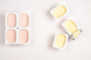 Plastic cup with tasty yogurt isolated on white. Top view. Space for text or design.