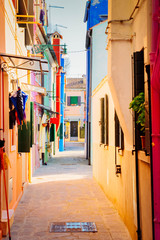 Fototapeta na wymiar narrow street in old town of Burano island, Venice, Italy, retro toned