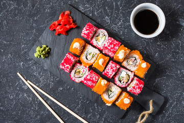 Obraz na płótnie Canvas Assorted sushi rolls set served on plate on stone background.