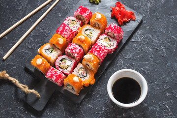 Assorted sushi rolls set served on plate on stone background
