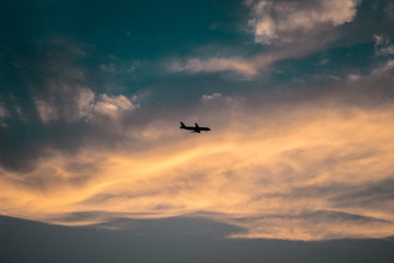 Fototapeta na wymiar silhouette of a passenger plane on the background of sunset clouds
