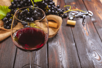 wine with branches of white grapes. On a wooden table.
