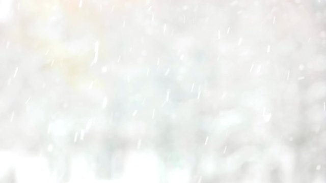 Blurred gray winter background. Falling snow and snowflakes. Winter fairy tale.