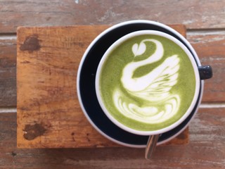 Hot green tea latte in a ceramic cup