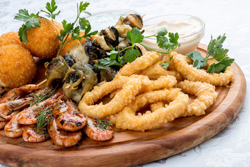 Assorted beer snacks. Cheese balls, mussels grill, shrimp, squid rings.