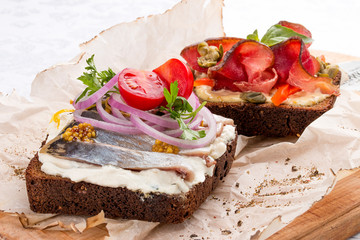 Toasts with venison, pepper and capers, herring and ricotta cheese