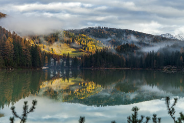 misty landscape with lake and mountains