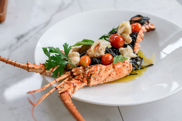 Tasty Phuket lobster with black spaghetti and tomato