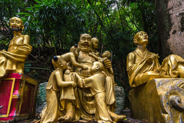 Close up of three golden Buddha statues along the path to Ten Thousand Buddhas Monastery, Hong Kong, Sha Tin, New Territories