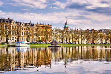 Fototapeta premium City lake with boat in front of the old town of Schwerin. Pfaffenteich lake.