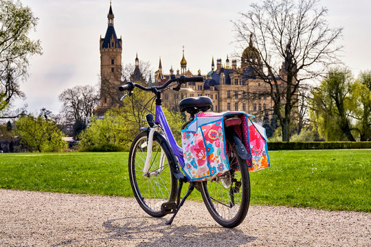 Children's bicycle with saddlebags in the park, with Schwerin Castle in the background.
