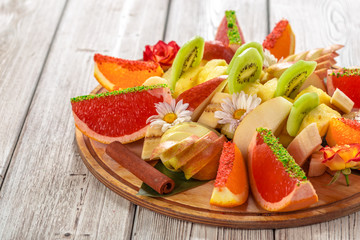 Fresh fruits in plate on wooden table