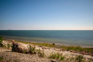 long exposure sea beach with rocks and washed out waves of water
