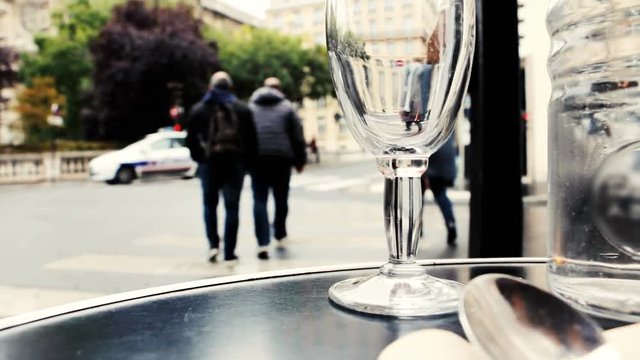 View on street of Paris from outdoor seating in restaurant. Selective focus. Defocused city life background. People unrecognizable.