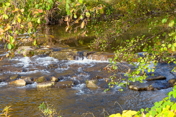 Fototapeta na wymiar Picturesque waterfall on a fast flowing stream