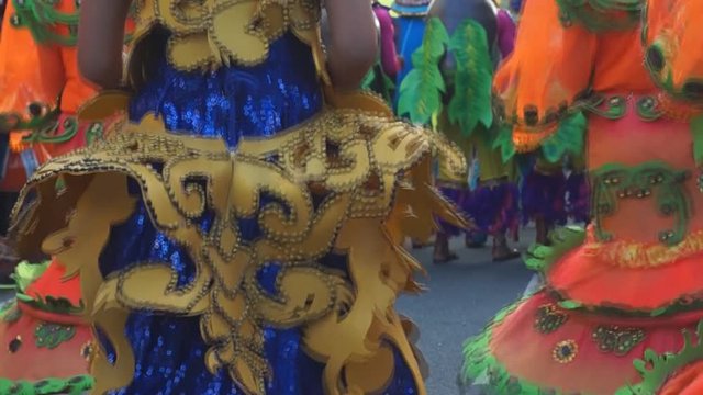 group of carnival folk and cultural dancers in colorful handcrafted coconut costume dance along the streets to honor a patron saint. Public Event