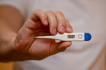 hand holding a thermometer