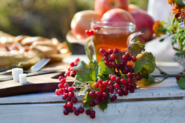 tea with kalina as a remedy for colds. Warming tea with viburnum and apple on a wooden table