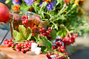 tea with kalina as a remedy for colds. Warming tea with viburnum and apple on a wooden table