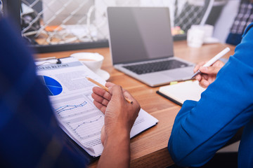 Businessmen and businesswomen discuss work at table with devices in hands isolated