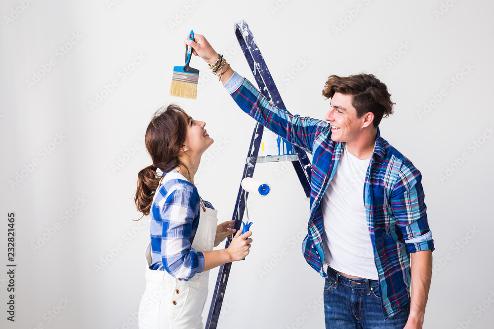 Wall mural teamwork, renovation and repair concept - portrait of funny couple doing redecoration in apartment