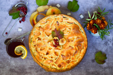 Apple tart. Open apple pie with cream filling with tea and viburnum