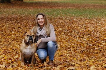 Naklejka na ściany i meble Middle age woman with her dog enjoying the autumnal nature