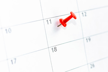 11 date pinning on calendar with Red color pin thumbtack. Save the Date. concept organization of working time